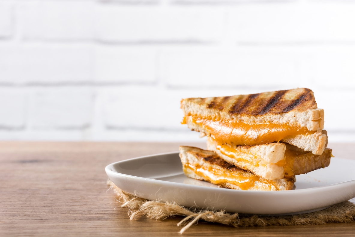 Grilled cheese sandwich on wooden table.